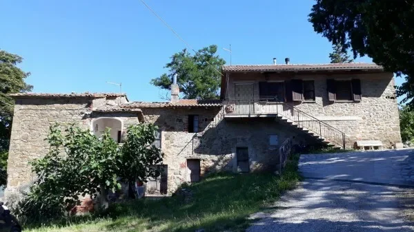 In a hilly area, property consisting of stone farmhouses with private land